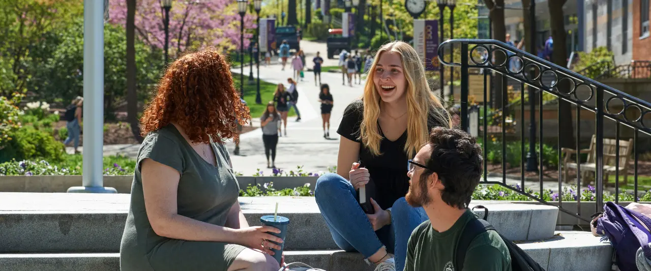 University of Scranton students talking and laughing on campus on a sunny spring day