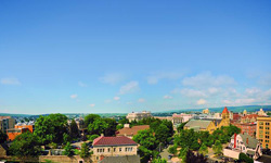 A panoramic view of the University of Scranton campus and surrounding cityscape under a bright blue sky with a few scattered clouds.
