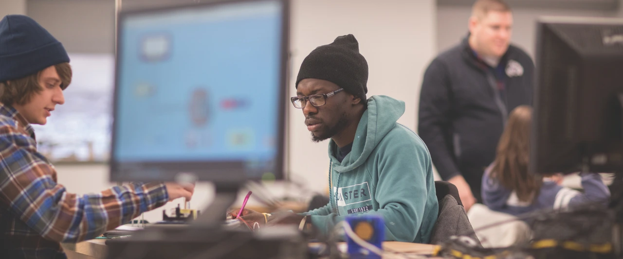 Two Scranton students working together on a project at a computer station in a lab